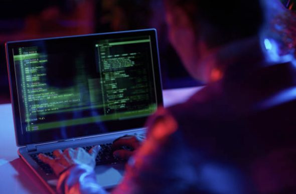 Person working at a laptop with code on screen