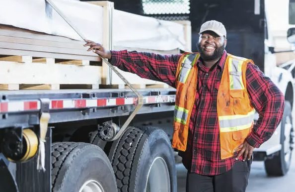 Warehouse worker standing beside a stopped truck